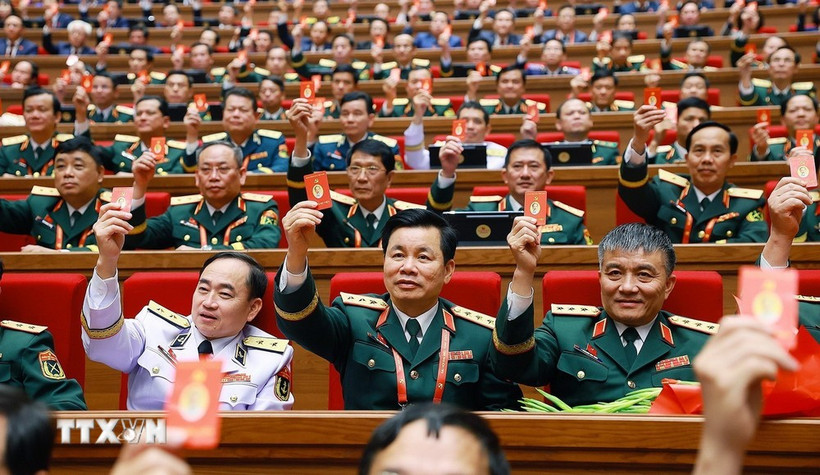 Les délégués votent pour approuver la Résolution du 14e Congrès national du Parti. (Photo : VNA)