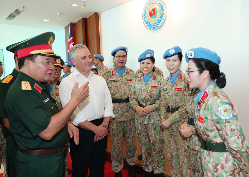 Le général de corps d’armée Hoàng Xuân Chiên, vice-ministre de la Défense et chef du Comité de pilotage du ministère sur la participation aux opérations de maintien de la paix de l’ONU, et Hugh Jeffrey, secrétaire général adjoint à la Défense de l’Australie échangent avec des femmes officiers de la Force vietnamienne de maintien de la paix. Photo : VNA