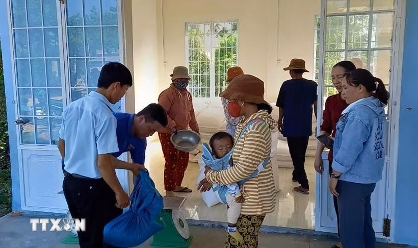 Distribuer du riz aux personnes démunies. Photo : VNA