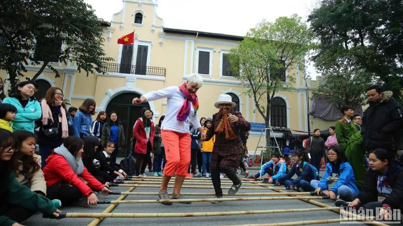 Les visiteurs internationaux découvrent des activités culturelles et des jeux folkloriques à Hanoi. (Photo : Thanh Dat/https://nhandan.vn/)