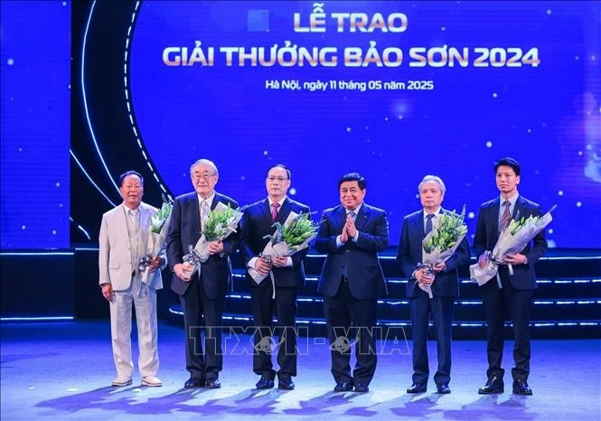 Le vice-Premier ministre Nguyen Chi Dung et Nguyen Truong Son, président du Fonds d'éducation et de formation Bao Son, président du groupe Bao Son prennnent une photo avec les lauréats du prix ​​Bao Son 2024. Photo : VNA