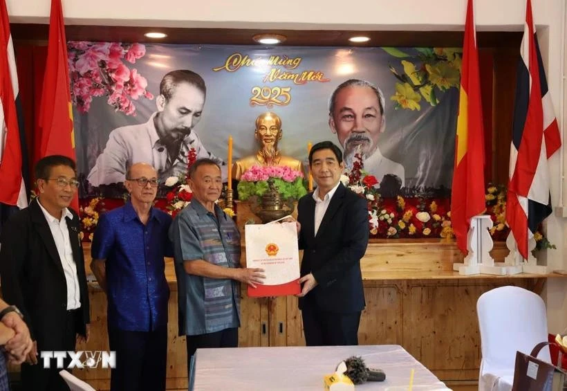 L’ambassadeur vietnamien, Pham Viet Hung (à droite) remet un cadeau à ,Nguyen Van Tri, président de l'Association des Vietnamiens de Sa Kaeo. Photo : VNA