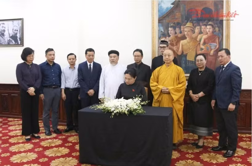 La vice-présidente et secrétaire générale du Comité central du FPV Ha Thi Nga écrit au registre de condoléance pour le président de l'Assemblée nationale lao, Saysomphone Phomvihane. Photo : daidoanket.vn.jpg
