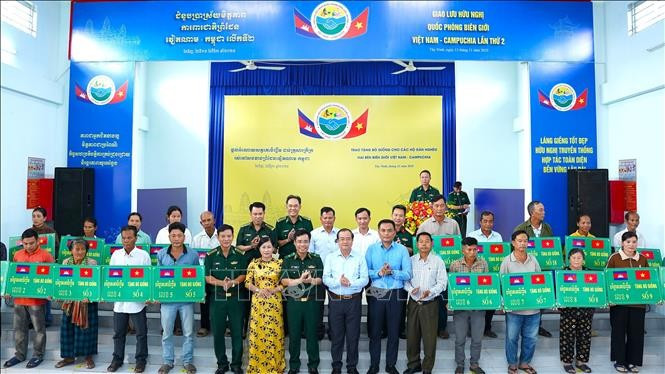Le Commandement des gardes-frontières, en coopération avec les autorités de la province vietnamienne de Tây Ninh et du district de Svay Teab (province cambodgienne de Svay Rieng), remet symboliquement 20 bovins à 20 familles défavorisées des communes de Long Thuân et Monorom. Photo : VNA