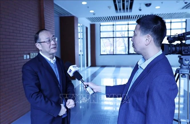 Le professeur Jin Canrong (gauche), directeur adjoint de l'Institut des relations internationales de l'Université populaire de Chine - l'Université Renmin de Chine, dans une interview accordée au correspondant de l’Agence vietnamienne d’information (VNA) à Pékin. Photo : VNA