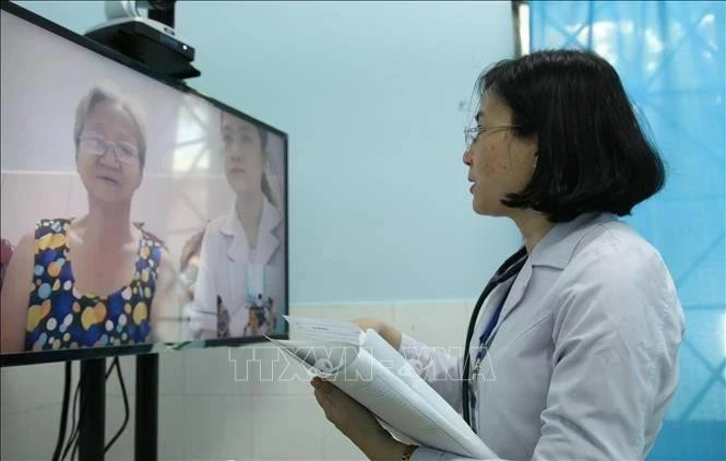 Un médecin du centre médical du quartier 16, district de Go Vap, à Ho Chi Minh-Ville, effectue un examen médical en ligne pour un patient. (Photo : VNA)