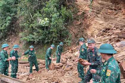 Des officiers et soldats du poste-frontière de Chieng On dégagent une route après un glissement de terrain. Photo : VNA