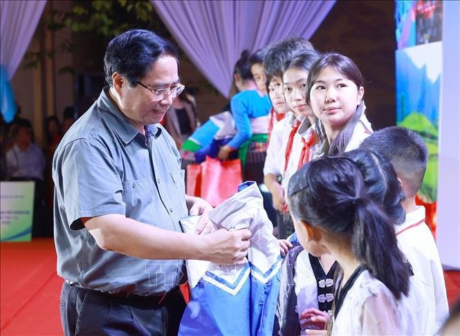 Le Premier ministre Pham Minh Chinh offre des cadeaux à des enfants de Bat Mot. Photo : VNA