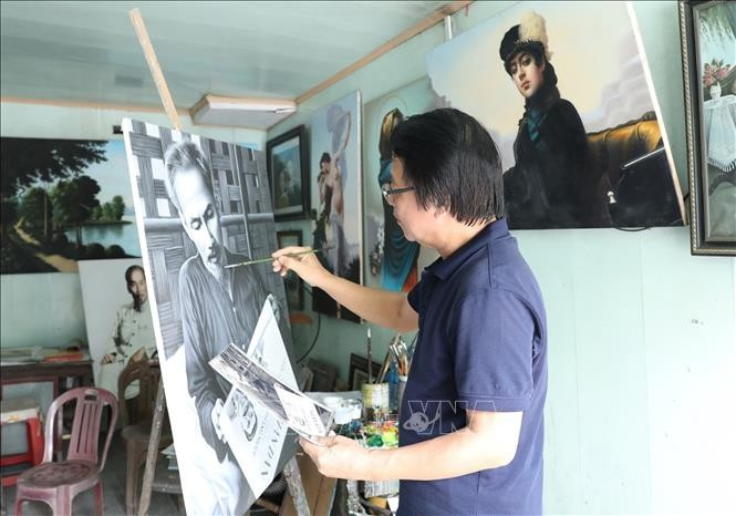 L'artiste Tran Hoa Binh peint le portrait de l'Oncle Ho. Photo : VNA