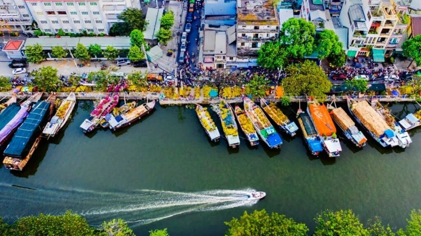 Des bateaux de fleurs ornementales venus de l'Ouest se rassemblent au quai de Binh Dông plusieurs jours avant le Têt. Photo : CVN