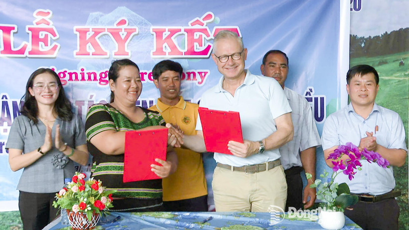 Mme Thi Khui, cheffe de la coopérative agricole d’anacarde biologique de Trang Co – Bu Lach, signe un accord de coopération pour l'achat de noix de cajou avec un représentant de la sarl Intersnack Vietnam. Photo : Journal Dong Nai
