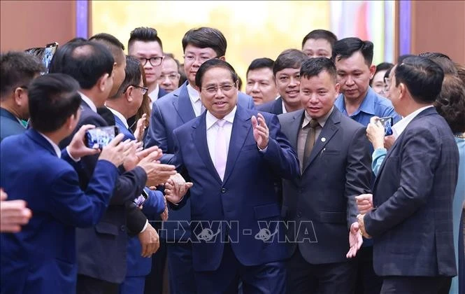 Le Premier ministre Pham Minh Chinh et des entreprises participant à l'échange de vue. Photo : VNA 