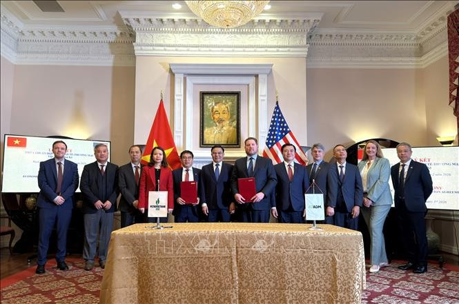 La cérémonie de signature d'un protocole d'accord entre des représentants vietnamiens et américains. Photo : VNA