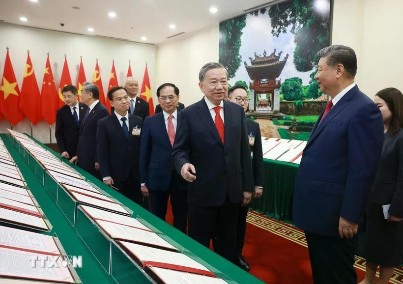 Le secrétaire général du Parti To Lam et le secrétaire général du Parti et président chinois Jinping assistent à la présentation des documents de coopération entre les deux pays. Photo : VNA
