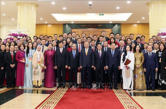 Le secrétaire général To Lam rencontre des Vietnamiens de l'étranger exemplaires participant au "Xuân Quê hương". Photo : VNA