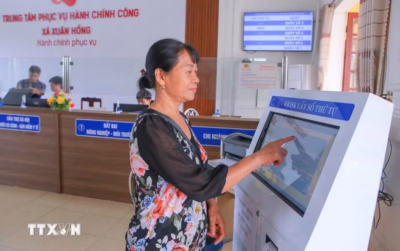 Une femme venue pour effectuer les démarches administratives au Centre de services de l'administration publique de la commune de Xuan Hong, à Ninh Binh. Photo : VNA