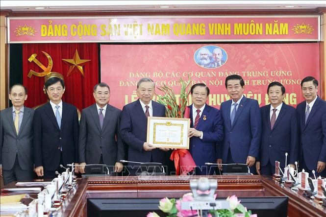 Le secrétaire général du Parti, Tô Lâm (4e à gauche) remet l'Insigne des 45 ans d'adhésion au Parti à Phan Dinh Trac. Photo : VNA