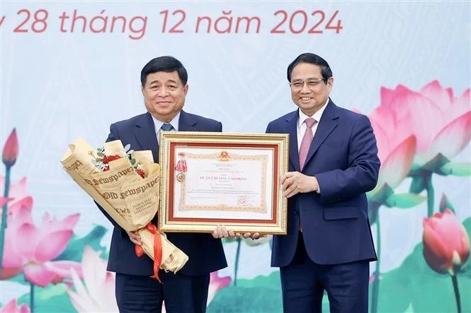 Le Premier ministre Pham Minh Chinh (droite) a décerné l'Ordre du Travail de première classe au ministre du Plan et de l'Investissement Nguyen Chi Dung. Photo : VNA