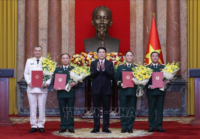 Le président Luong Cuong remet les décisions de promotion au grade de général de corps d’armée à quatre officiers supérieurs de l’Armée et de la Police populaires du Vietnam. Photo : VNA