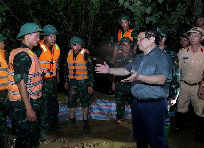 Le Premier ministre inspecte les opérations de lutte contre les inondations dans la nuit. Photo : VNA