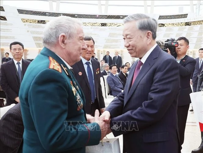 Le secrétaire général To Lam (droite) rencontre et offre des cadeaux aux vétérans biélorusses qui ont apporté des contributions exceptionnelles au Vietnam. Photo : VNA