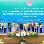 Le Premier ministre Pham Minh Chinh offre des fleurs de félicitations aux jeunes Vietnamiens exemplaires. Photo : VNA