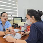 Des fonctionnaires du quartier de Mao Khe guident une citoyenne dans le dépôt en ligne de ses dossiers de certification sur le Portail national de la fonction publique. Photo : TTXVN