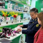 Guider une femme à distinguer des cosmétiques authentiques de produits contrefaits. Photo : Vietnam+