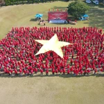 Plus d'un millier de Vietnamiens forment ensemble le Drapeau rouge à l’étoile d’or. Photo: VNA