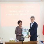 L'ambassadeur Nguyen Minh Vu remet des cadeaux du Têt à Ha Thi E, qui a contribué à la résistance contre l'armée américaine et a reçu un certificat de mérite du Premier ministre vietnamien en 2009. Photo : VNA
