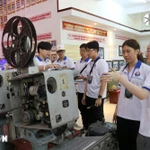 Des jeunes Vietnamiens d’outre-mer découvrent une boussole spécialisée utilisée dans les années 1980, à l’Académie navale. Photo : VNA