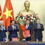 Le président de l’Assemblée nationale, Tran Thanh Man, a remis la décision, et le Premier ministre Pham Minh Chinh a offert des fleurs pour féliciter Nguyen Hong Dien. Photo: VNA