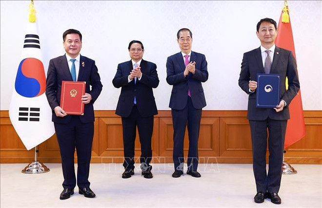 Les deux chefs des gouvernements vietnamien Pham Minh Chinh et sud-coréen Han Duck Soo assistent à la cérémonie de signature des documents de coopération bilatérale. Photo : VNA 1.jpg