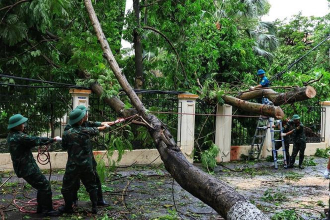 Des militaires aident à nettoyer les dégâts du typhon. Photo: VNA 1.jpg
