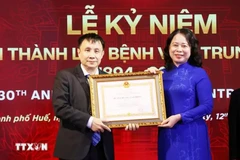 La vice-présidente Vo Thi Anh Xuan décerne l'Ordre du travail de première classe au professeur Dr Pham Nhu Hiep, directeur de l'hôpital central de Huê. Photo : VNA