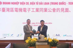 Le directeur du comité de gestion de la zone économique de Hai Phong, Le Trung Kien (droite), offre un cadeau au représentant de la délégation de TEEMA. Photo: VNA 