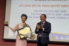 Le ministre vietnamien de la Culture, des Sports et du Tourisme, Nguyen Van Hung, remet la décision de reconduction de Anoa Suzanne Dussol Perran comme ambassadrice du tourisme du Vietnam en France. Photo: VNA