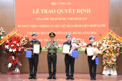 Le ministre de la Sécurité Publique, Luong Tam Quang, remet la décision du président à trois officiers. Photo: bocongan.gov.vn