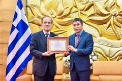 Le président de l'Union des organisations d'amitié du Vietnam (VUFO), Phan Anh Son (à droite), a décerné l’Insigne "Pour la paix et l'amitié entre les peuples" à l'ambassadeur de Grèce au Vietnam Georgios Stilianopoulos. Photo : VNA