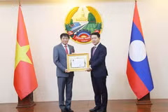Le vice-Premier ministre et ministre des Affaires étrangères du Laos, Saleumxay Kommasith (droite), remet la noble distinction à l'ambassadeur Nguyen Ba Hung. Photo : VNA