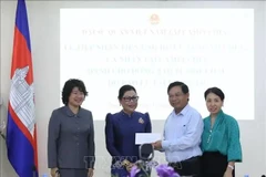 Chea Sam Eng, représentante des Cambodgiens qui ont étudié au Vietnam au début des années 1980 remis un don pour soutenir les les victimes des récentes catastrophes naturelles au Vietnam. Photo : VNA