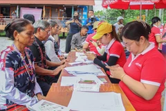 Le comité d'organisation aide des habitants de l'ethnie Co Tu à enregistrer des cartes SIM. Photo: VNA