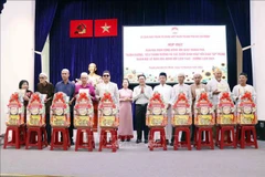 Pham Minh Tuan, vice-président du Comité municipal du FPV (centre) remet des cadeaux aux représentants des Conseils de gestion des mosquées et des oratoires à l'occasion de la fête Raya Idil Adha. Photo: VNA
