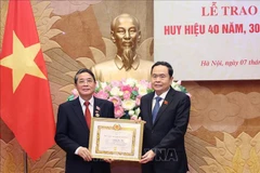 Le membre du Bureau politique, Trân Thanh Mân, secrétaire du Comité chargé des affaires du Parti de l'Assemblée national (AN) et président de l'AN (droite) remet l’Insigne des 40 ans du Parti à Nguyên Duc Hai, membre du Comité central (CC) du Parti, membre du Comité chargé des affaires du Parti de l’AN, vice-président de l’AN. Photo: VNA