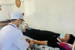Un travailleur médical prend soin de la santé des gens à la clinique Vinh Hau A, district de Hoa Binh, province de Bac Lieu. Photo : VietnamPlus 