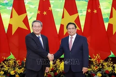 Le Premier ministre Pham Minh Chinh (à droit) et son homomogue chinois Li Qiang se serrent la main. Photo: VNA