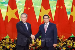 Le Premier ministre Pham Minh Chinh (à droit) et son homomogue chinois Li Qiang se serrent la main. Photo: VNA