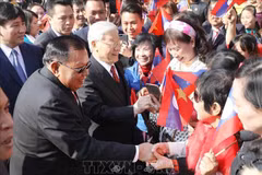 Le secrétaire général du Parti Nguyen Phu Trong et le secrétaire général du Parti et président du Laos Bounnhang Vorachith rencontrent des habitants , à Hanoi, le 22 juillet 2024. Photo : VNA