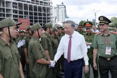 Le président de la République Tô Lâm serre la main des membres de la force de défense de la sécurité et de l’ordre au niveau local. Photo : VNA
