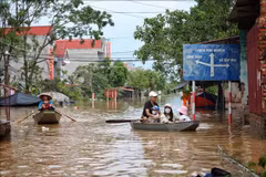 Les habitants de la commune Tri Yen, district de Yên Dung, province de Bac Giang empruntent des barques pour traverser une route inondée, le 13 septembre 2024. Photo : VNA